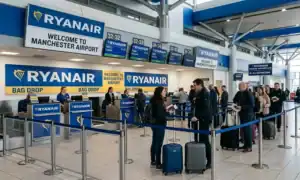 Passengers queuing at a Ryanair bag drop check-in area inside Manchester Airport Terminal 3